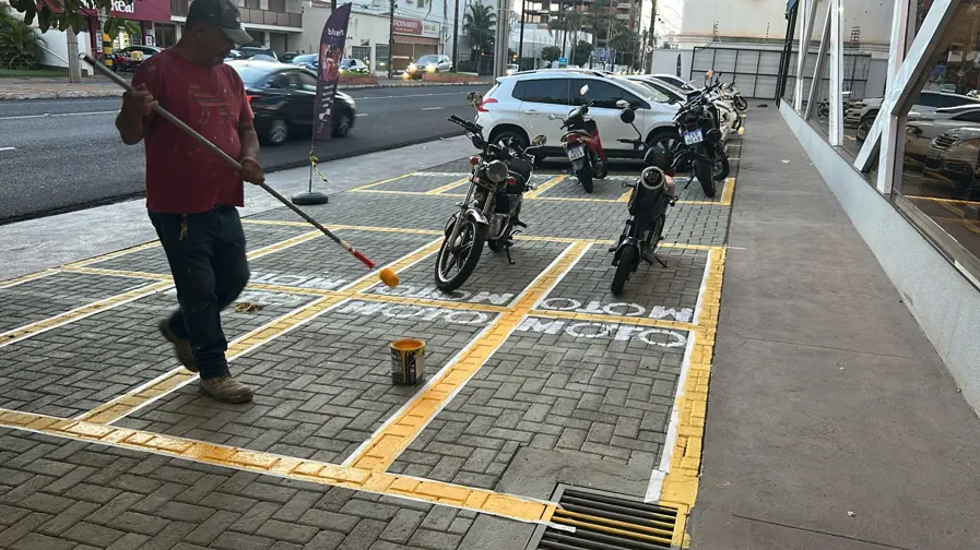 Profissional pintando a demarcação das vagas de um estacionamento