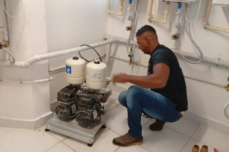 Técnico fazendo manutenção nas bombas de pressurização de água de um edifício